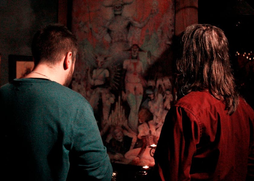 Two people looking at a painting at an exhibition.